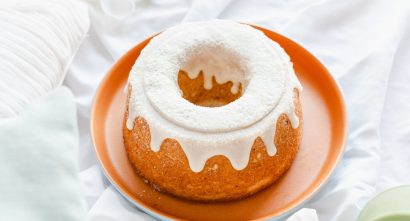 bundt cake with white frosting on a tray
