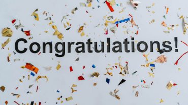 black text "Congratulations!" on a white background with colorful confetti surrounding it
