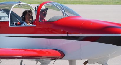 CSA Learner sitting in the cockpit of a red airplane