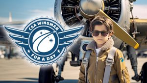 Young aviator standing in front of an airplane