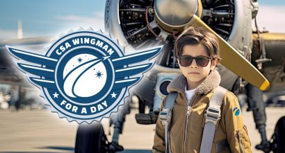 Young aviator standing in front of an airplane